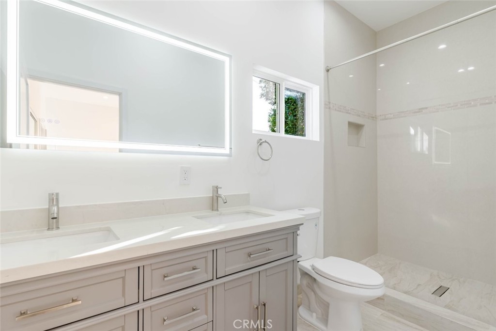 6852 Ranchito Avenue Van Nuys, CA 91405 - Photo 16 of 18 a bathroom with a sink a toilet and a mirror