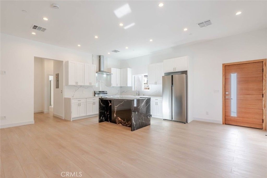 6852 Ranchito Avenue Van Nuys, CA 91405 - Photo 4 of 18 a kitchen with stainless steel appliances kitchen island granite countertop a refrigerator and cabinets