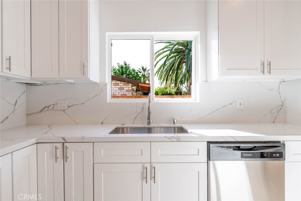 6852 Ranchito Avenue Van Nuys, CA 91405 - Photo 9 of 18 a kitchen with stainless steel appliances white cabinets and a window