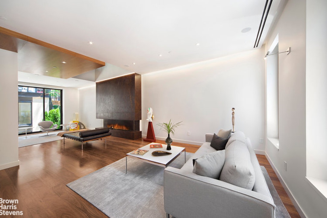 251 East 61st Street Manhattan, NY 10065 - Photo 10 of 39 a living room with furniture and a flat screen tv