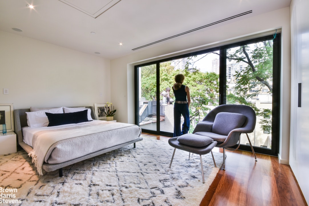 251 East 61st Street Manhattan, NY 10065 - Photo 14 of 39 a bedroom with a bed and a large window