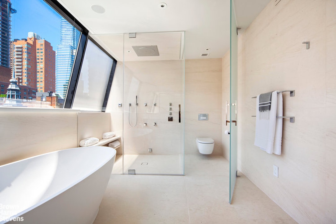251 East 61st Street Manhattan, NY 10065 - Photo 16 of 39 a spacious bathroom with a bathtub and a shower