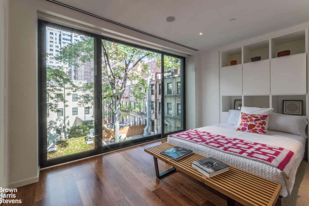 251 East 61st Street Manhattan, NY 10065 - Photo 17 of 39 a bedroom with a bed and wooden floor