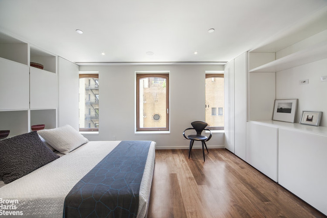 251 East 61st Street Manhattan, NY 10065 - Photo 19 of 39 a bedroom with a bed and wooden floor