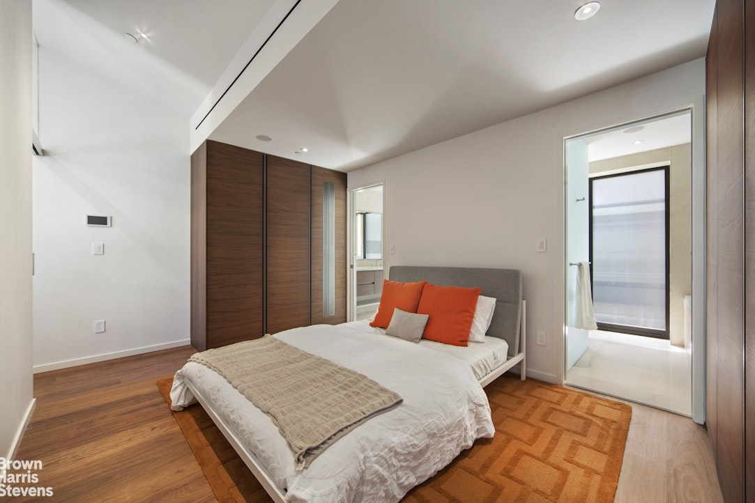 251 East 61st Street Manhattan, NY 10065 - Photo 23 of 39 a bedroom with a large bed and wooden floor