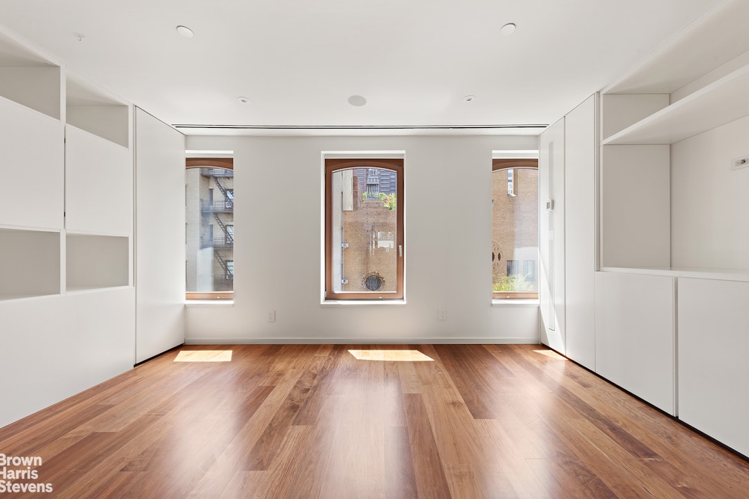 251 East 61st Street Manhattan, NY 10065 - Photo 27 of 39 a view of an empty room with wooden floor and a window