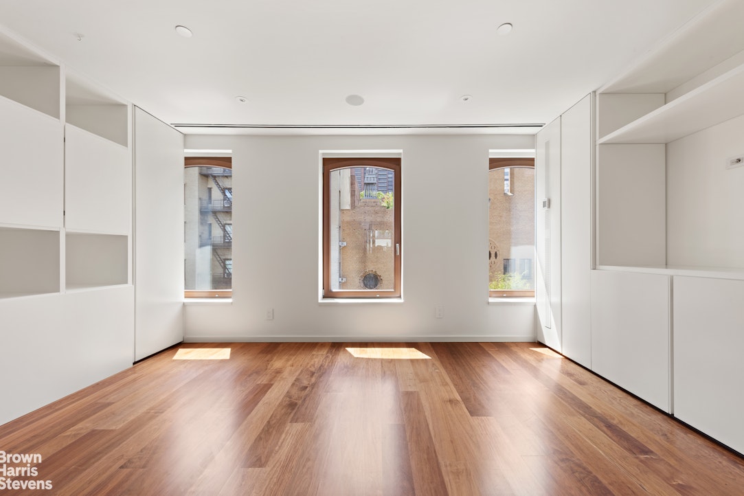 251 East 61st Street Manhattan, NY 10065 - Photo 28 of 39 an empty room with wooden floor and windows