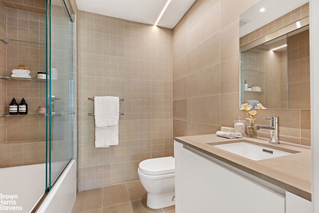 251 East 61st Street Manhattan, NY 10065 - Photo 29 of 39 a bathroom with a sink a toilet and shower