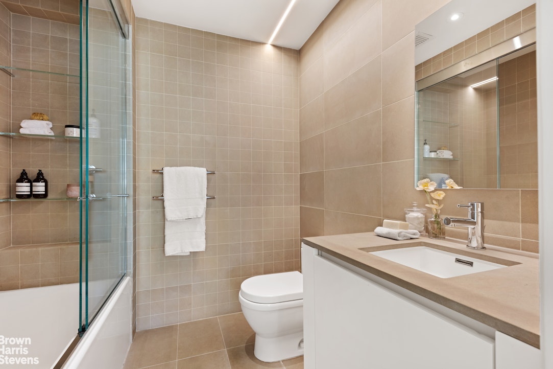 251 East 61st Street Manhattan, NY 10065 - Photo 30 of 39 a bathroom with a sink a toilet and shower