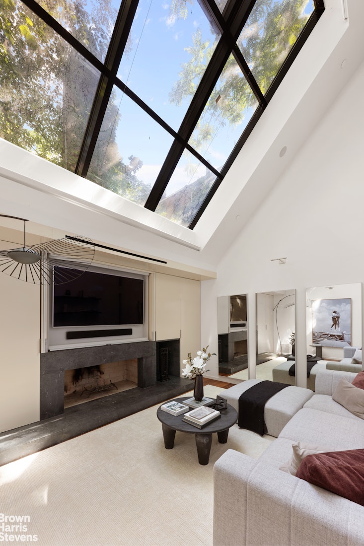 251 East 61st Street Manhattan, NY 10065 - Photo 34 of 39 a living room with furniture and a flat screen tv