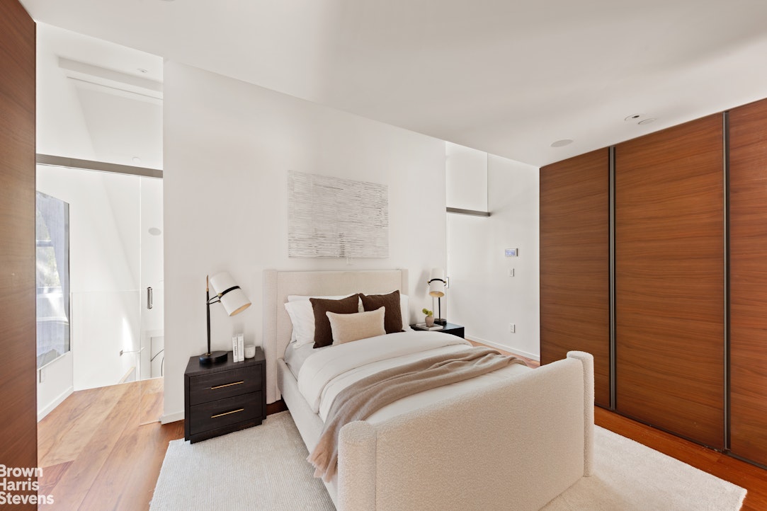 251 East 61st Street Manhattan, NY 10065 - Photo 36 of 39 a bedroom with a bed and a walk in closet