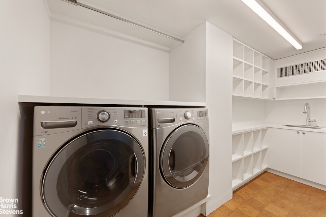 251 East 61st Street Manhattan, NY 10065 - Photo 37 of 39 a view of a storage & utility room with washer and dryer