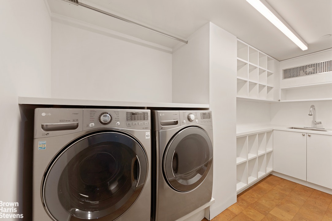 251 East 61st Street Manhattan, NY 10065 - Photo 38 of 39 a view of a storage & utility room with washer and dryer