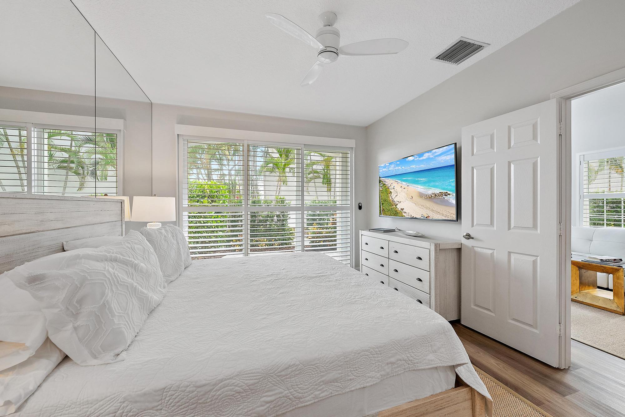 1000 North Us Highway, Unit 700 Jupiter, FL 33477 - Photo 13 of 32 a spacious bedroom with a bed and a flat screen tv