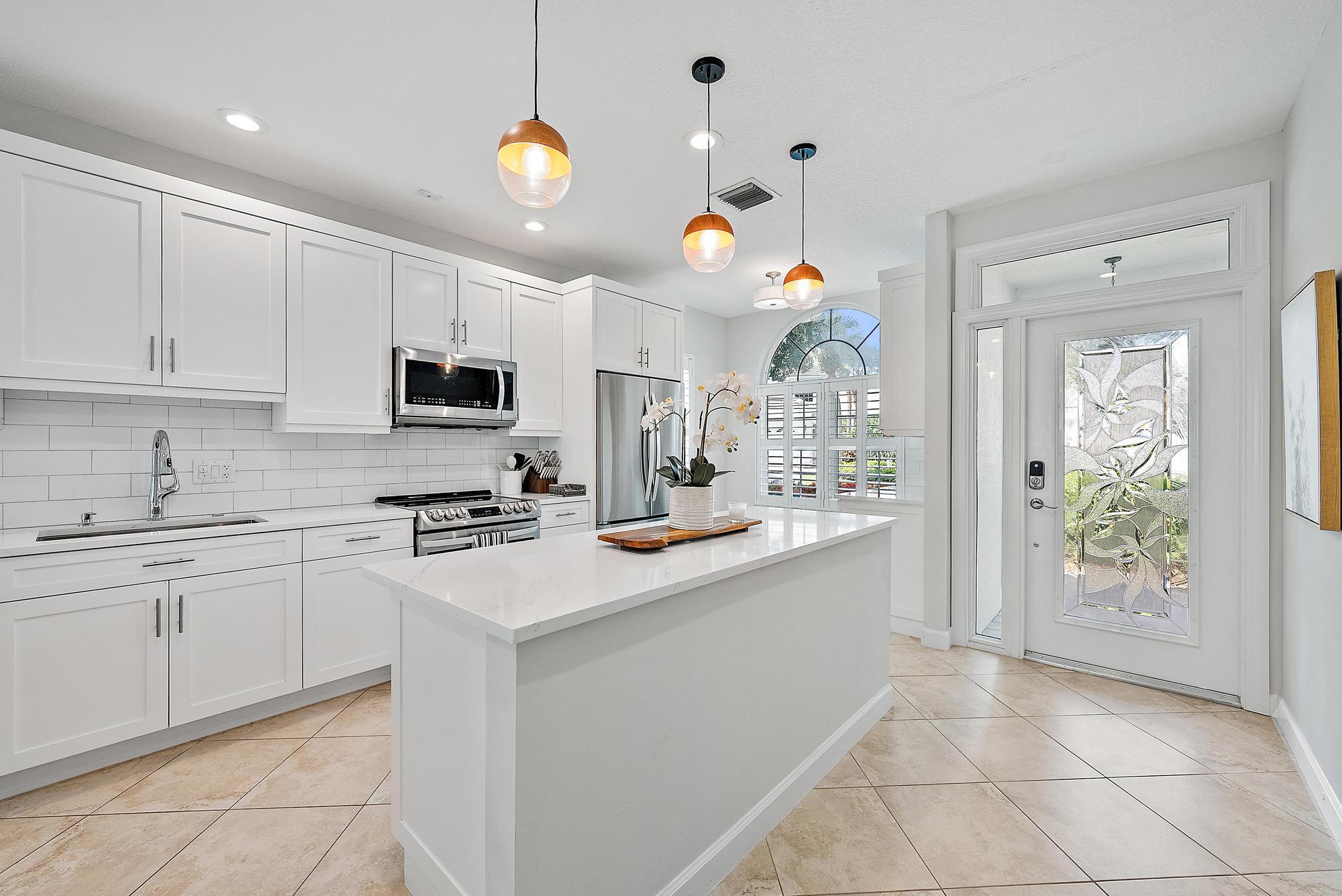 1000 North Us Highway, Unit 700 Jupiter, FL 33477 - Photo 3 of 32 a kitchen with kitchen island granite countertop a sink a stove top oven a counter space and cabinets