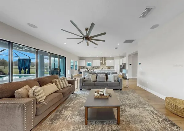 a living room with furniture and a view of kitchen