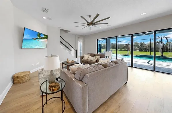 a kitchen with stainless steel appliances kitchen island granite countertop a dining table chairs and a refrigerator