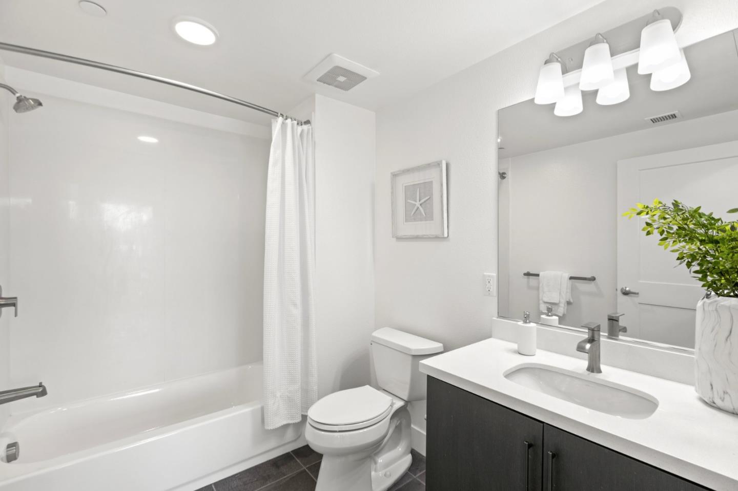 42111 Osgood Road, Unit 215 Fremont, CA 94539 - Photo 20 of 44 a bathroom with a sink a toilet a mirror a bathtub and shower