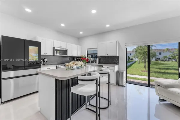 a kitchen with stainless steel appliances kitchen island granite countertop a sink and cabinets
