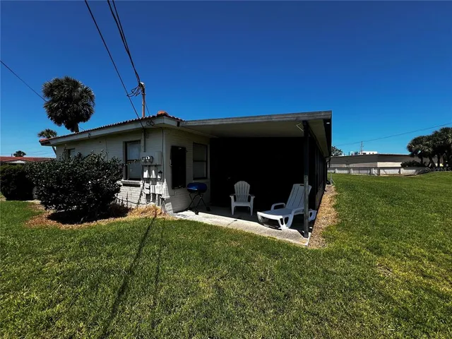 a view of a backyard with table and chairs and potted plants
