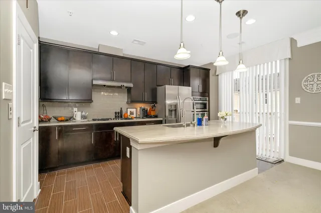 a kitchen with stainless steel appliances granite countertop a sink a stove and a refrigerator