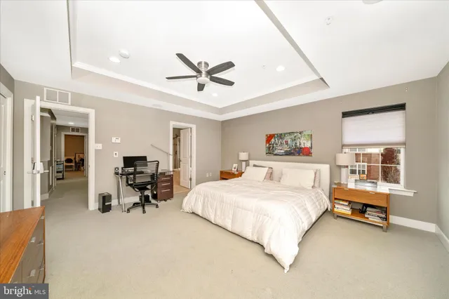 a spacious bedroom with a bed a table and chair