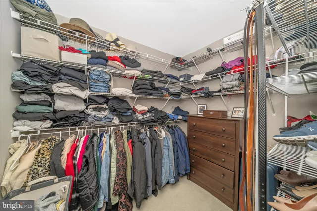 a view of walk in closet with clothes