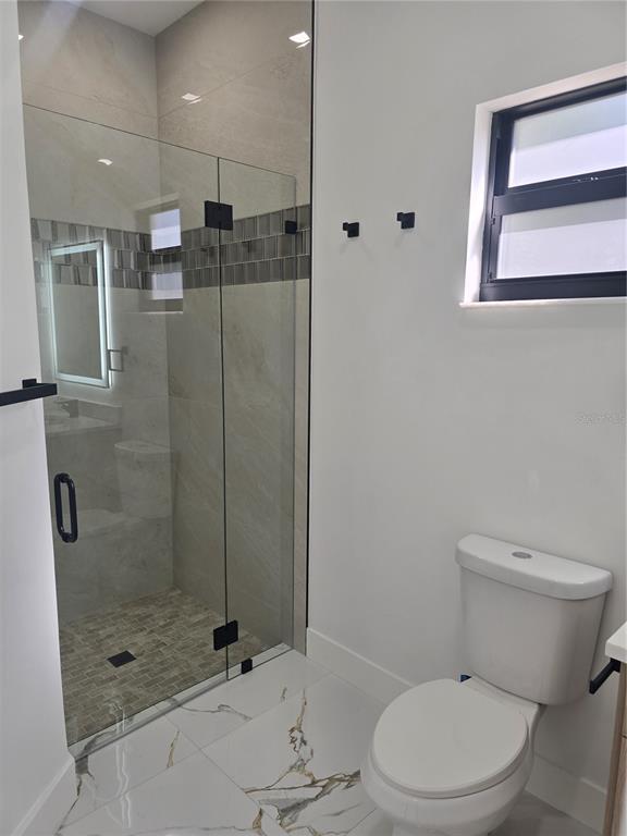5823 Whippoorwill Drive Tampa, FL 33625 - Photo 25 of 31 a bathroom with a toilet and shower