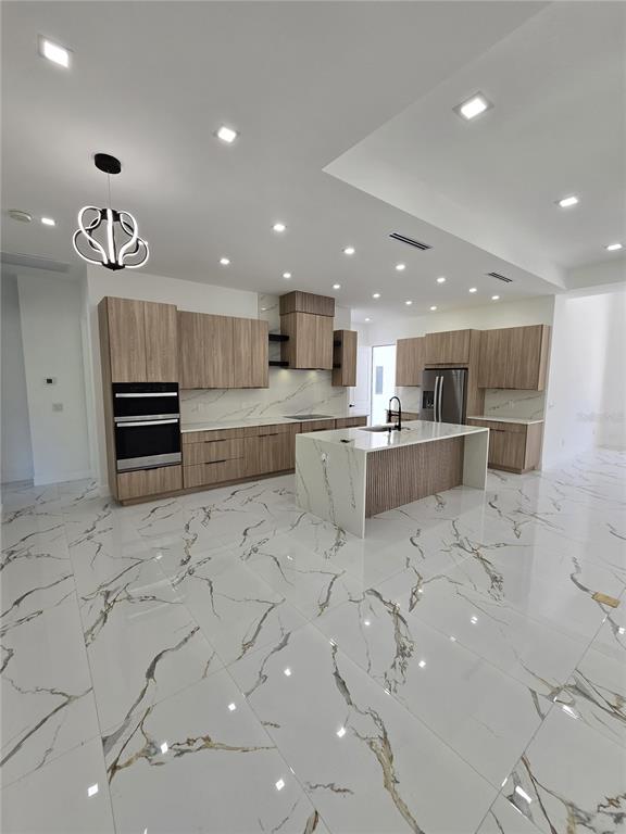 5823 Whippoorwill Drive Tampa, FL 33625 - Photo 7 of 31 a large kitchen with stainless steel appliances lots of white cabinets