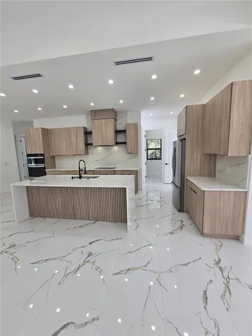 a large kitchen with stainless steel appliances lots of counter top space