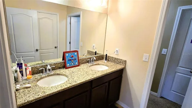 a bathroom with a granite countertop sink and a mirror