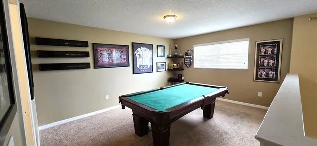a room with furniture pool table and window