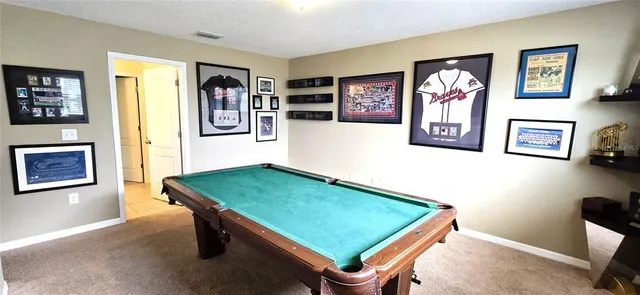a room with pool table and paintings on the wall