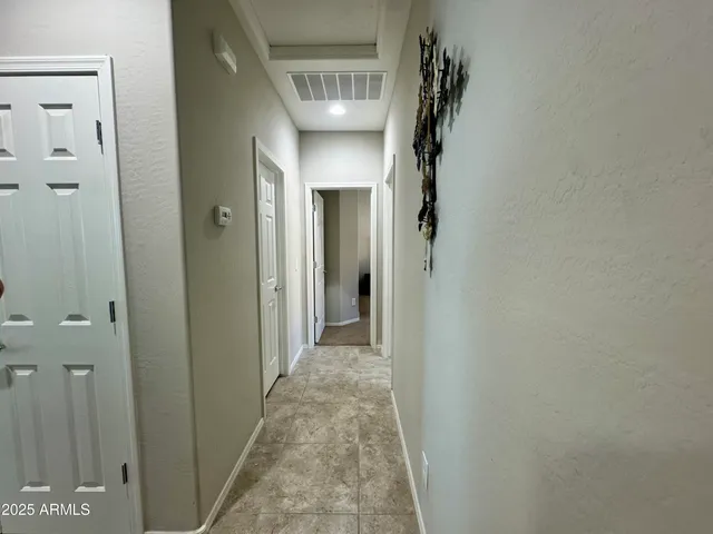 a view of a hallway with wooden shelves