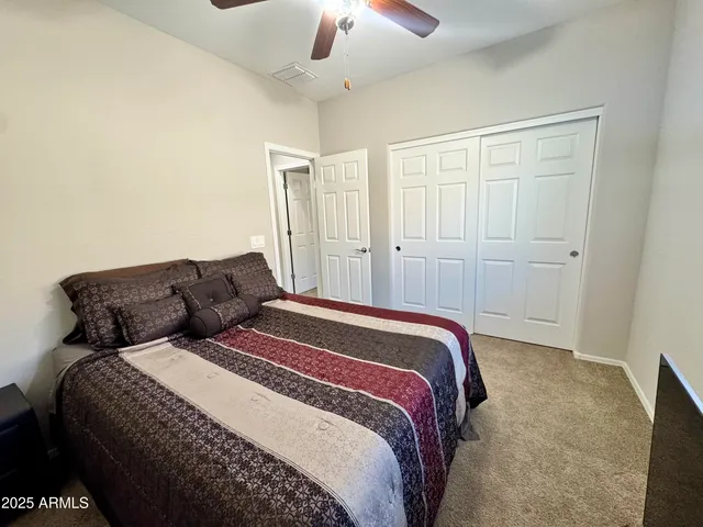 a spacious bedroom with a bed and a chandelier