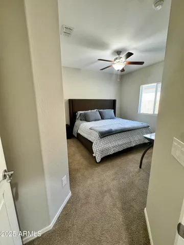 a bedroom with a bed and a ceiling fan