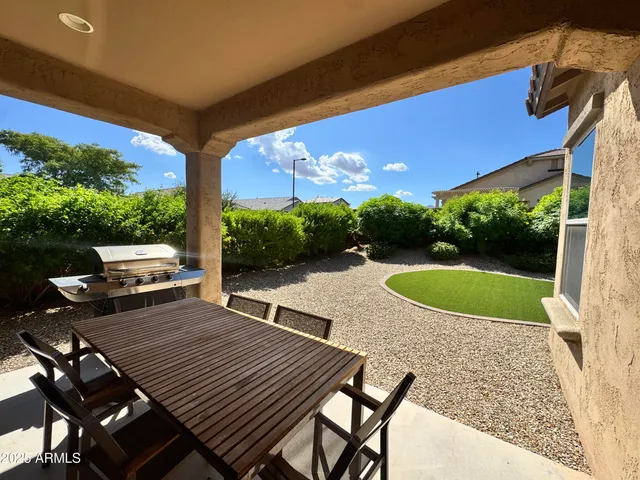 a view of a patio with table and chairs potted plants with wooden floor and fence