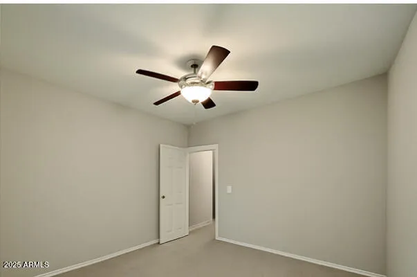 an empty room with window and ceiling fan