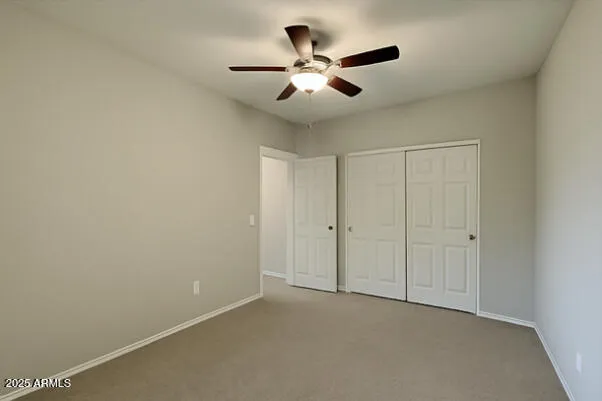 an empty room with closet and fan