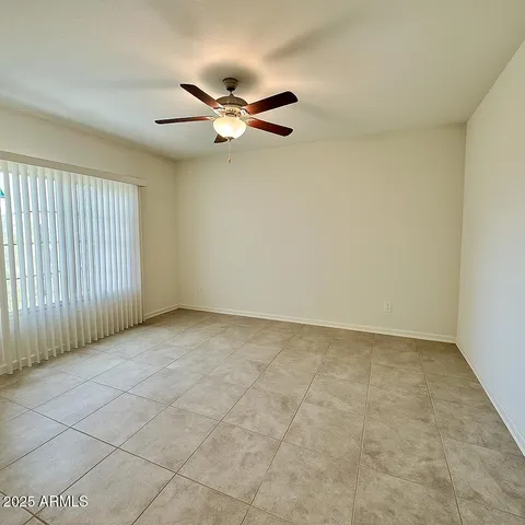 an empty room with windows and fan