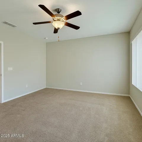 an empty room with a window and a fan