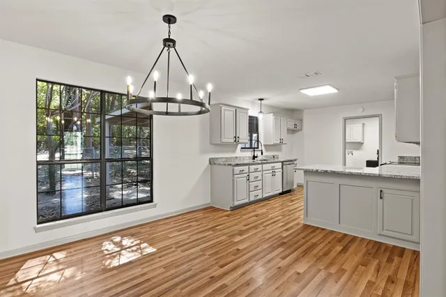 a kitchen with stainless steel appliances a white cabinets and wooden floor