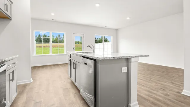 a kitchen with kitchen island a sink wooden floor and a large window