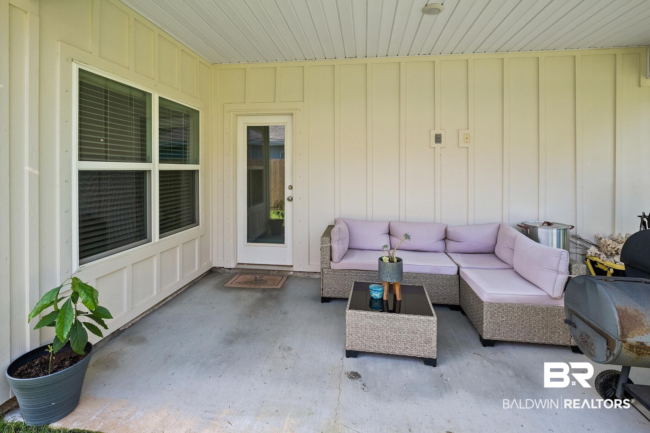 23997 Veranda Circle Elberta, AL 36530 - Photo 24 of 28 Covered patio featuring a concrete slab, board and batten siding, white framed windows, and a glass-paneled door