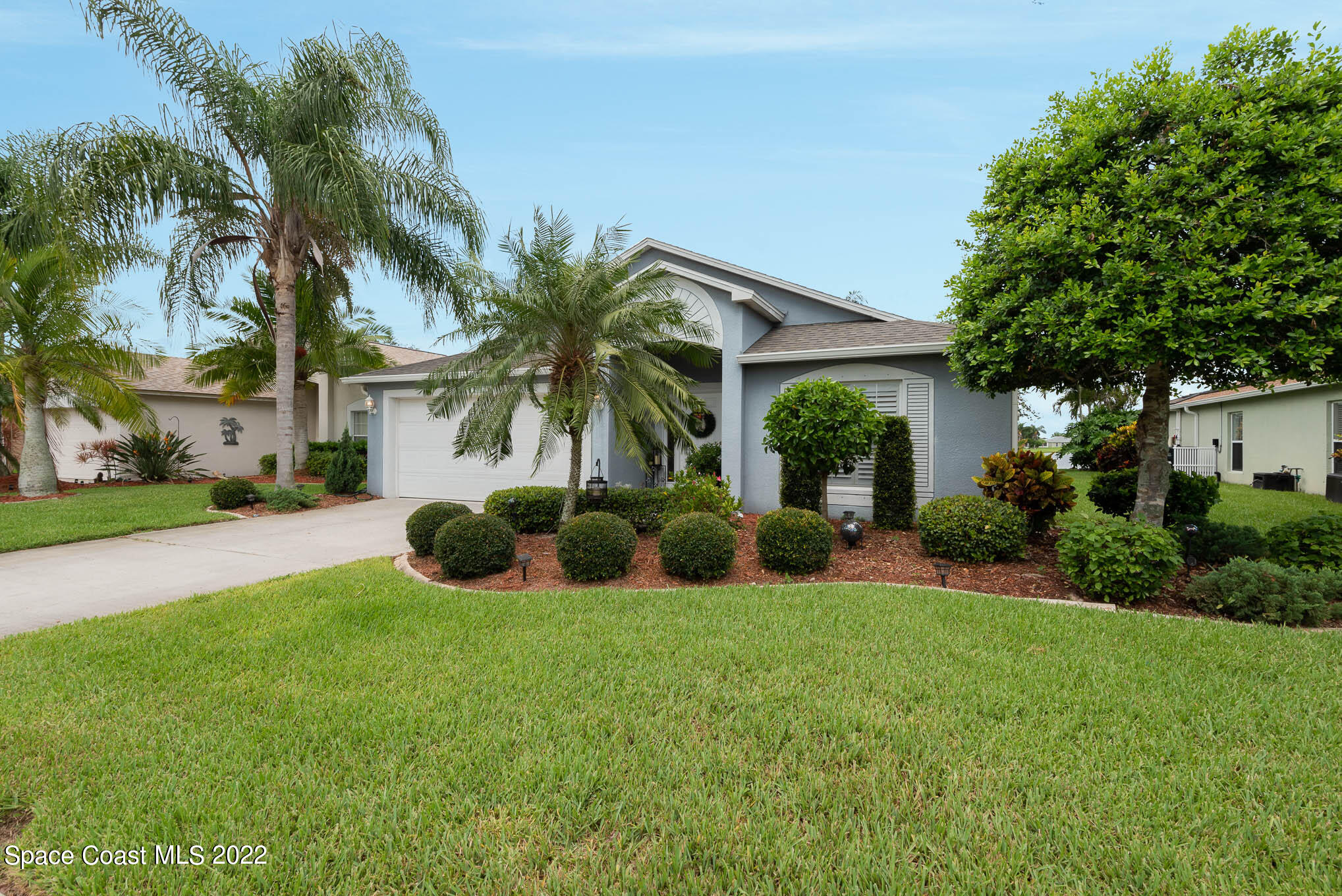 1063 Brumpton Place Rockledge, FL 32955 - Photo 1 of 33 a view of a house with a yard and palm trees
