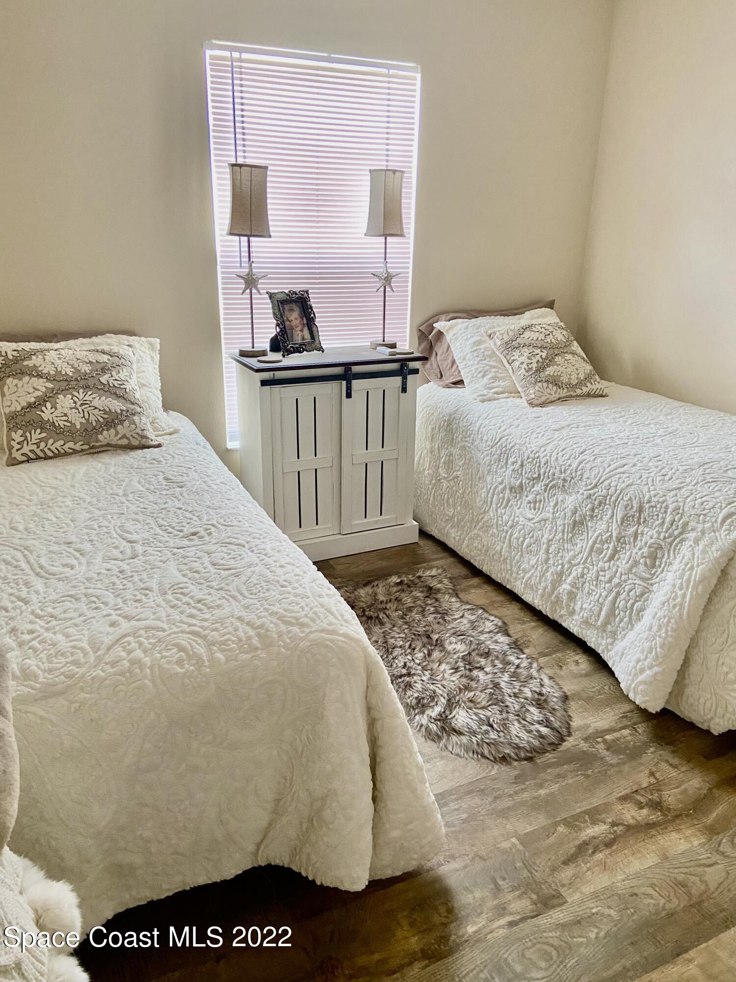 1063 Brumpton Place Rockledge, FL 32955 - Photo 18 of 33 a bedroom with a bed and wooden floor