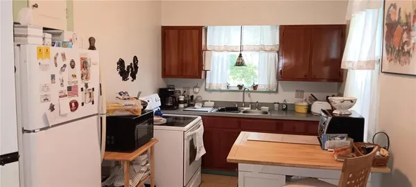 a kitchen with stainless steel appliances sink refrigerator table and chairs