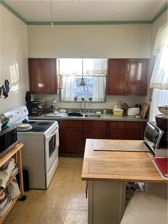 a kitchen with a stove a sink a counter space and cabinets