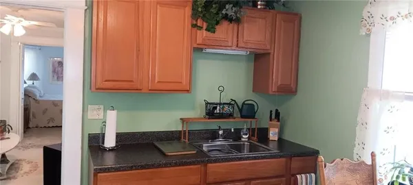 a kitchen with stainless steel appliances granite countertop a coffee maker on granite counter tops and white cabinets with wooden floor