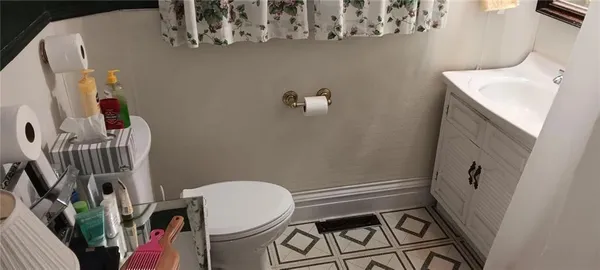 a bathroom with a sink a toilet and shower curtain